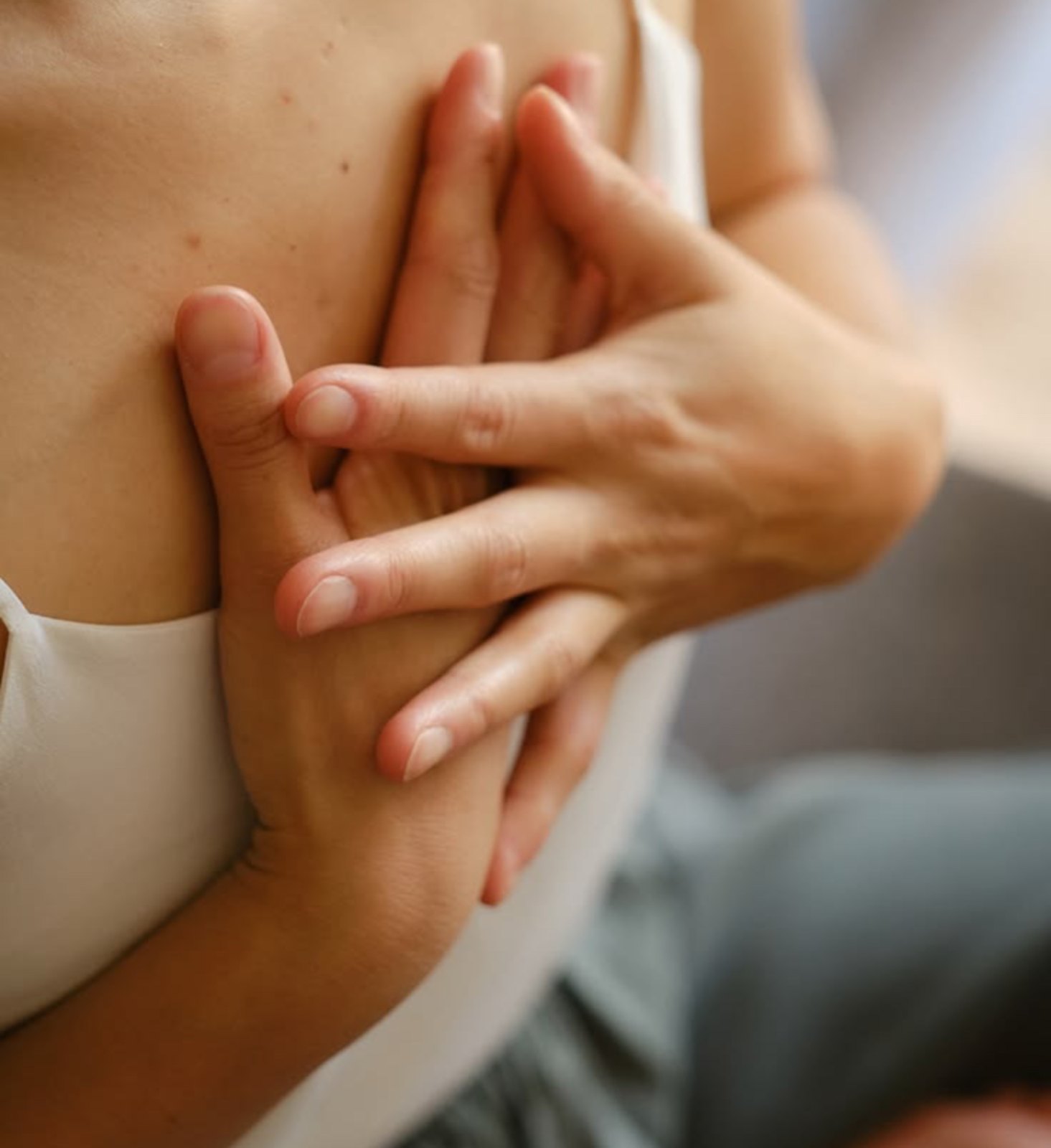 Two hands resting over the heart
